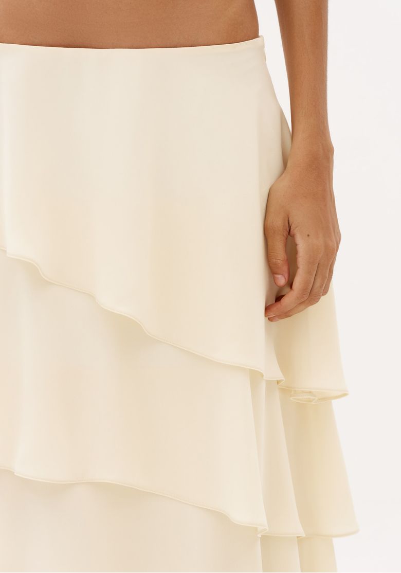 Detalhe-da-saia-off-white-de-cintura-media-com-tecido-leve-e-sobreposicoes-fluidas