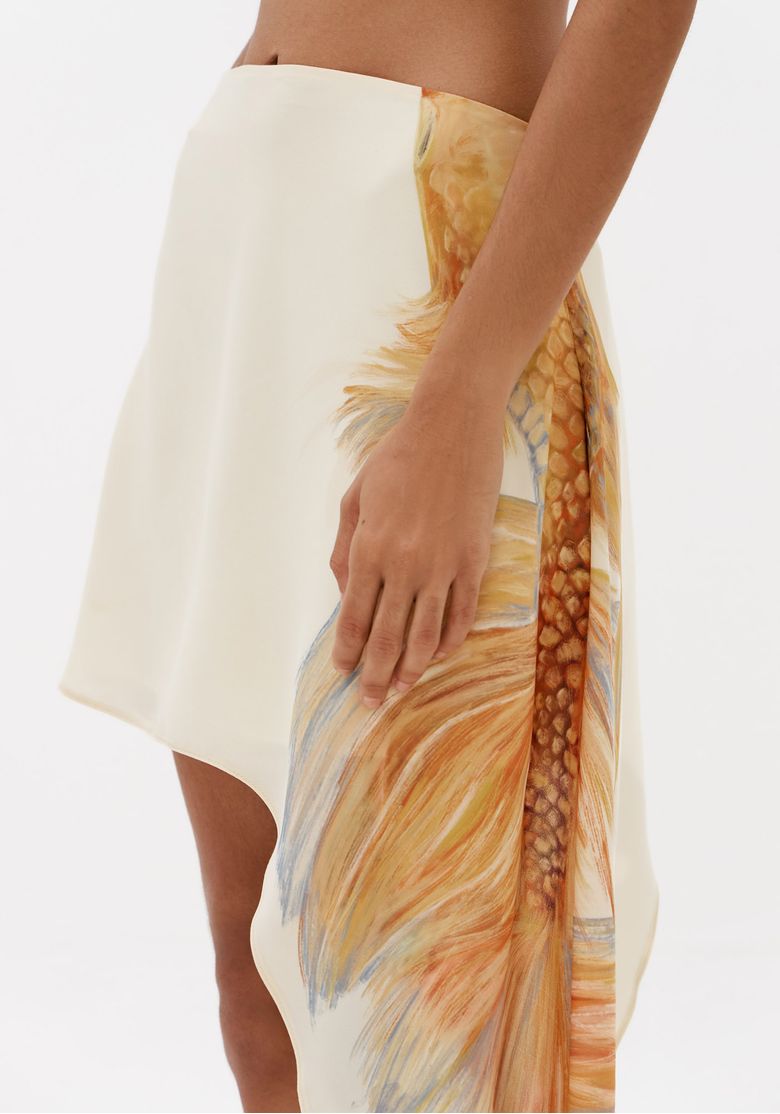 Close-do-cos-e-lateral-de-saia-curta-branca-estampada-com-modelagem-assimetrica-feminina