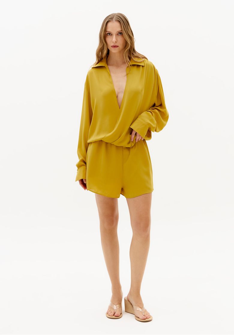 Close-frontal-de-macacao-curto-amarelo-com-manga-longa-ampla-gola-aberta-e-caimento-fluido-elegante