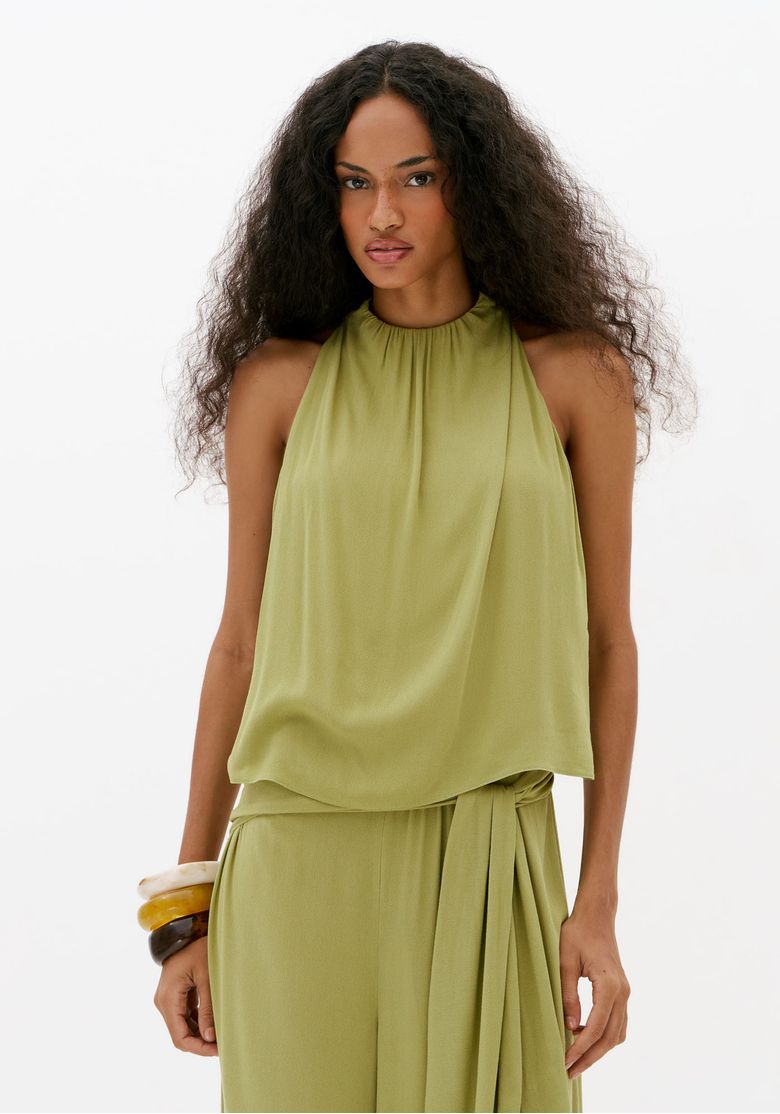 Close frontal de macacão longo verde feminino com gola alta franzida, caimento fluido e detalhe de faixa lateral