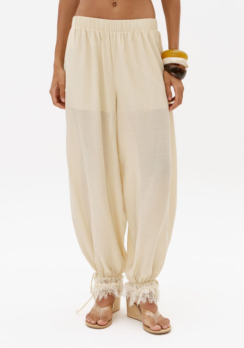 Close-frontal-de-calca-aladim-off-white-feminina-com-cos-elastico-e-barra-com-renda-tecido-leve-e-modelagem-solta