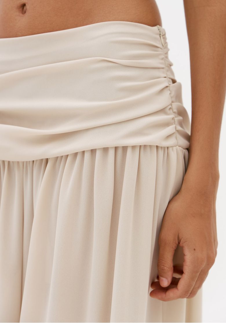 Close-da-cintura-de-calca-off-white-com-pala-drapeada-em-chiffon-e-detalhe-franzido-lateral