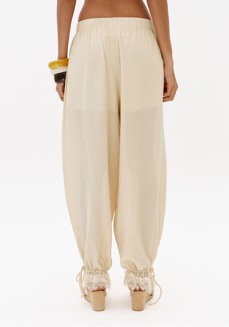 Vista-traseira-da-calca-aladim-off-white-com-cintura-media-cos-elastico-e-modelagem-ampla-estilo-boho