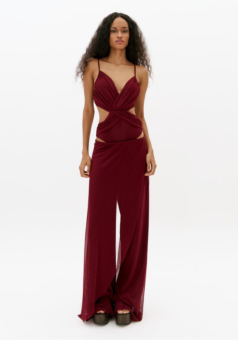 Modelo vestindo calça reta bordô de cintura média com sobreposição de tule e caimento fluido em look feminino sofisticado