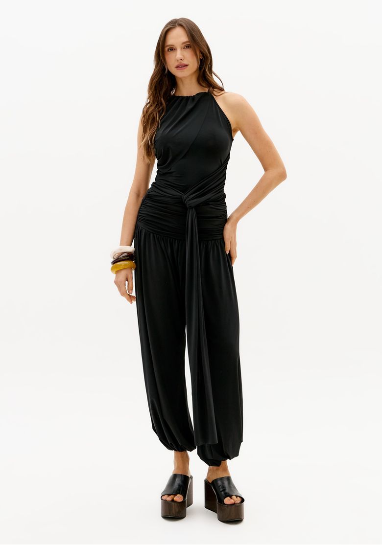 Modelo usando calça saruel preta de malha pesada com cintura média e barra ajustada, em look casual feminino moderno