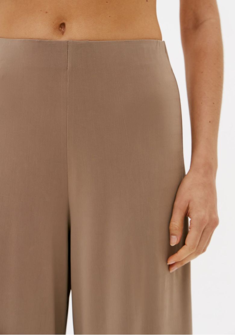 Detalhe do cós simples da calça wide leg bege feminina em malha pesada com cintura média