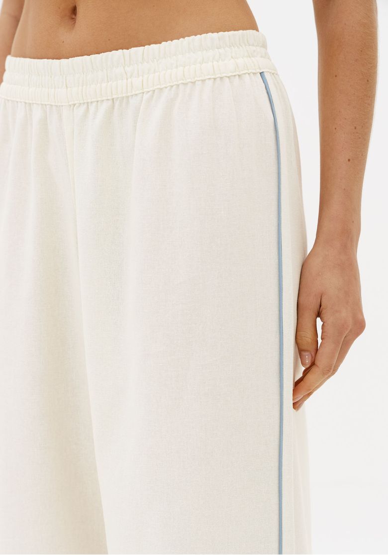 Detalhe-da-calca-off-white-com-cos-elastico-e-faixa-lateral-contrastante-em-tecido-leve-com-linho