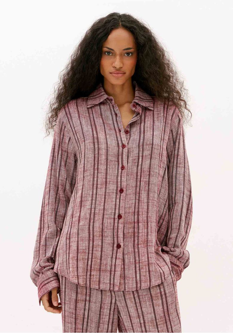 Camisa feminina oversized listrada bordô com linho, manga longa e caimento amplo vista frontal em foto aproximada