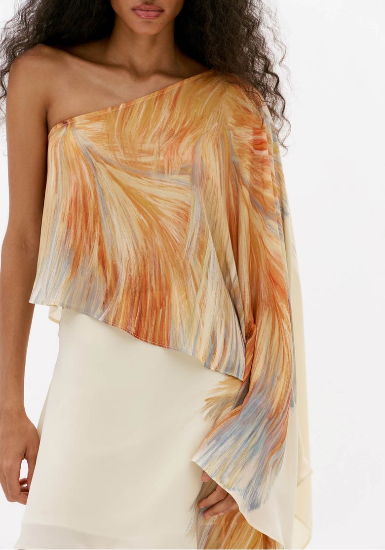 Close-da-blusa-ombro-unico-estampada-com-estampa-abstrata-em-branco-e-tons-alaranjados-manga-longa-fluida