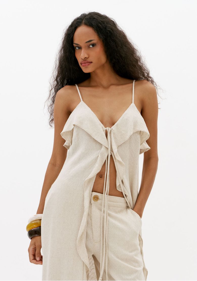 Vista-frontal-aproximada-da-blusa-feminina-off-white-alongada-com-linho-caimento-fluido-alcas-finas-e-recorte-com-amarracao