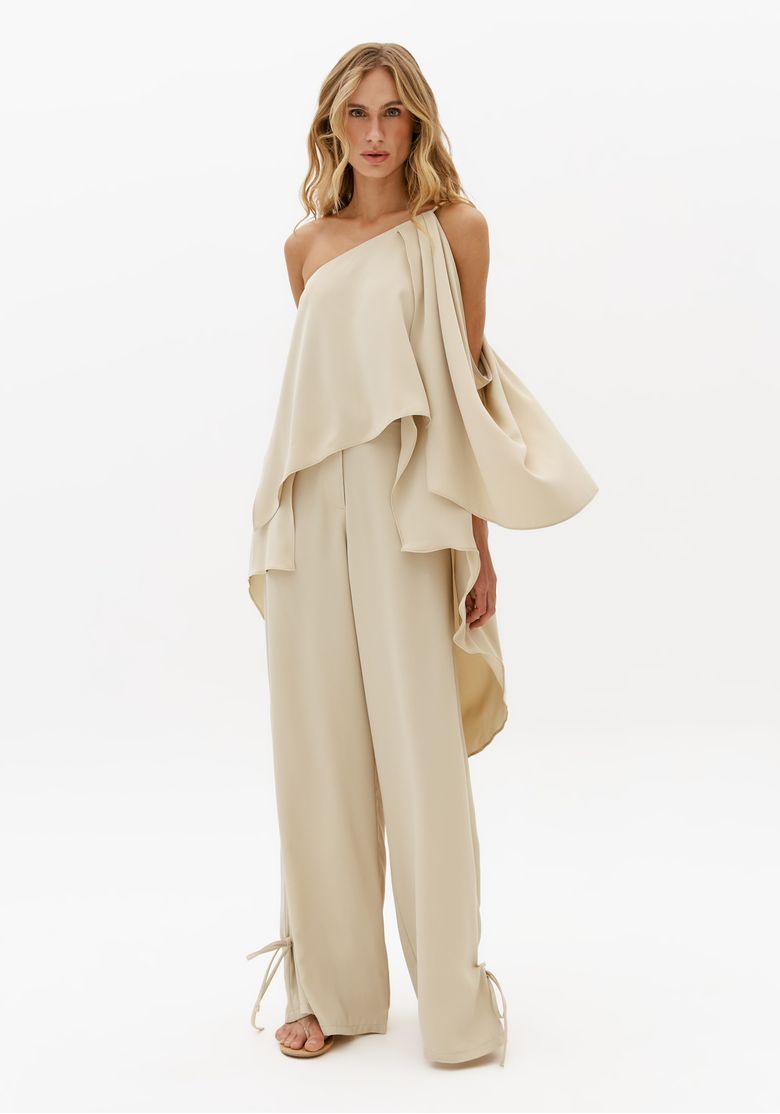 Look completo com blusa alongada ombro único off white e calça ampla feminina em visual sofisticado e minimalista