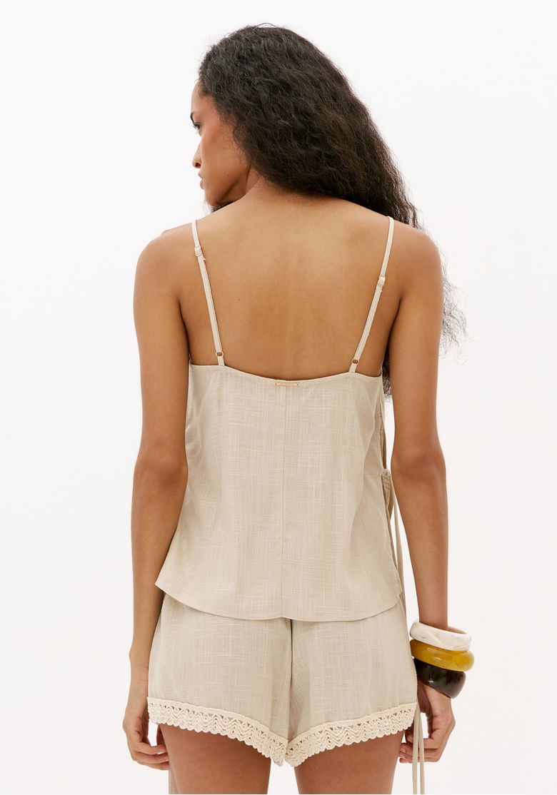 Vista traseira da blusa feminina off white com alças finas reguláveis e caimento solto em tecido leve com linho