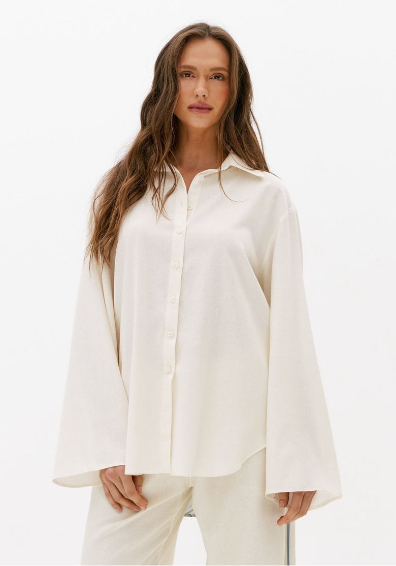 Vista frontal de camisa feminina alongada branca com linho, gola clássica, abotoamento frontal e mangas longas amplas